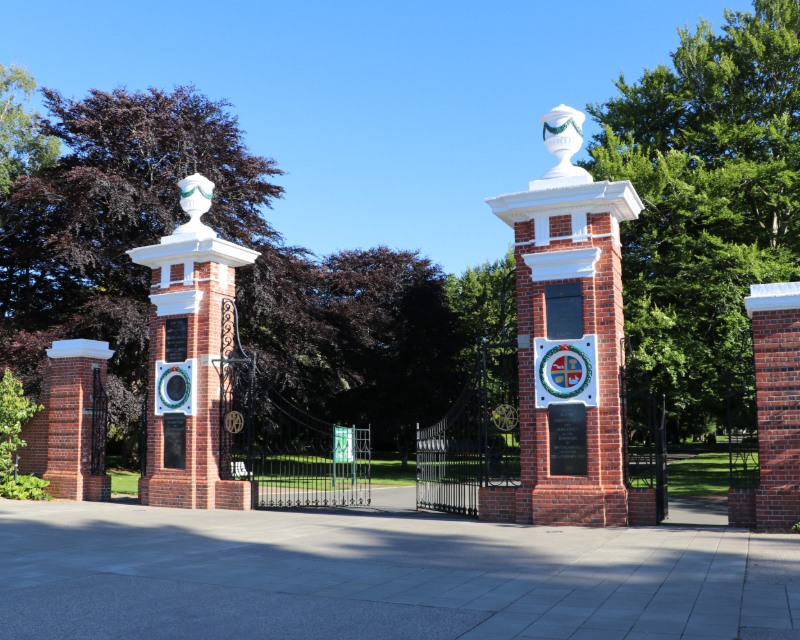 The brick and white painted Feldwick Gates stand at the entrance of Queens Park.