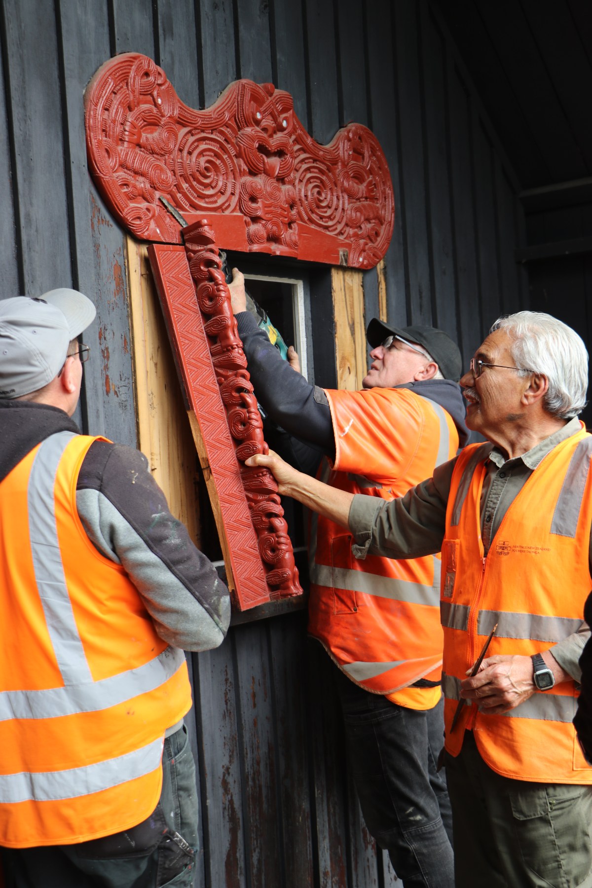 Marae conservation expert Jim Schuster oversees the removal of carvings from Te Wharepuni o Anehana at  Anderson Park, with Invercargill City Council carpenters Wayne McGill and Michael O’Neill. 